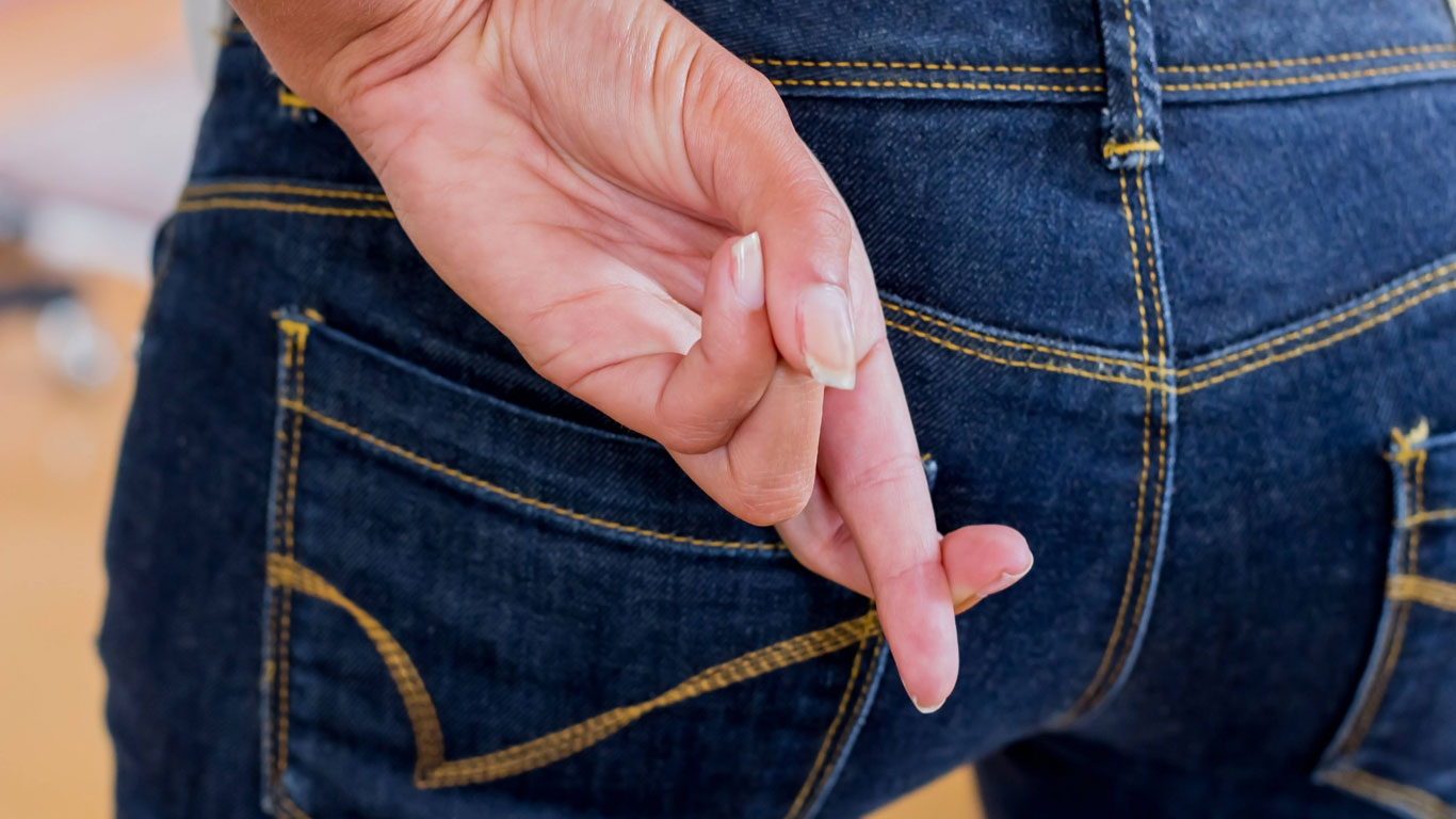 Finger hinter dem Rücken kreuzen