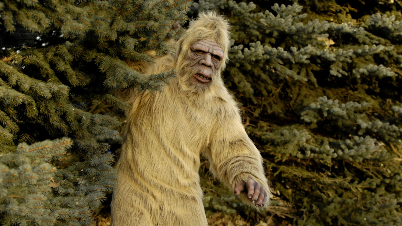 Bigfoot schaut hinter einem Baum hervor