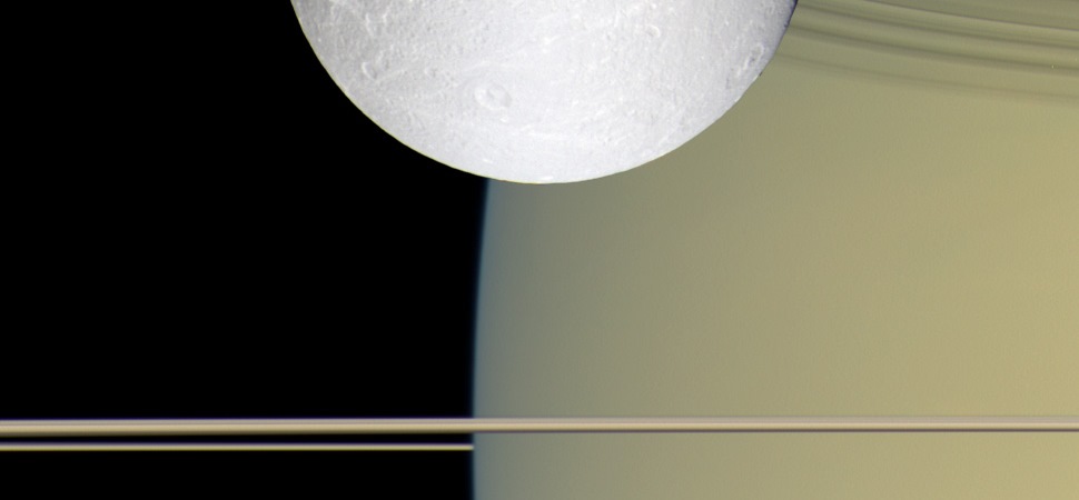 Auf dem Bild erkennt man hinter dem Saturmond Dione in goldenen und blauen Farben den Saturn. Die horizontal verlaufenden Streifen in der unteren Bildhälfte sind die Saturnringe. Zum Zeitpunkt der Aufnahme des Bildes befand sich Cassini beinahe auf einer Höhe mit den Saturnringen.