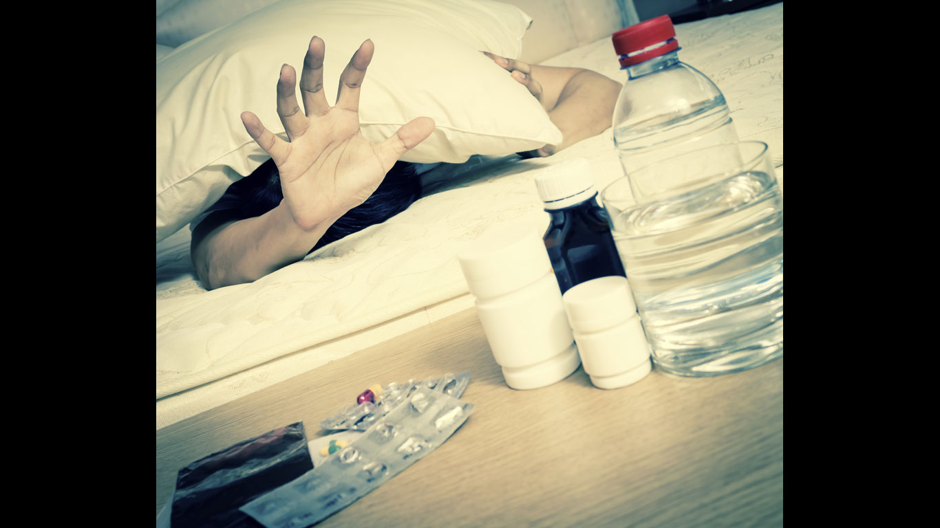 Hand greift nach Medikamenten
